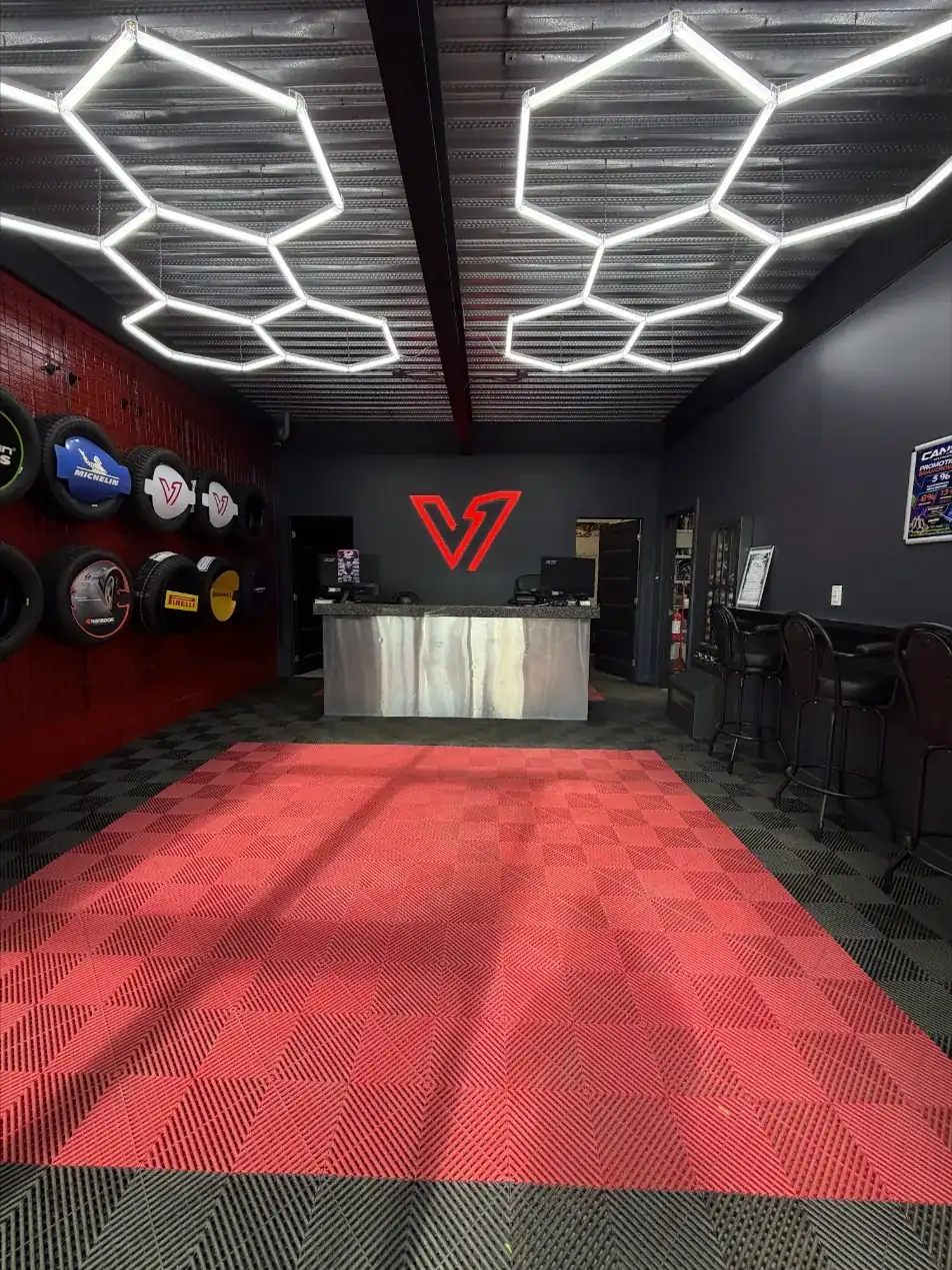 Reception of V1 Pneus + Mécanique in St-Léonard: lit hexagon ceiling, V1 logo on the wall